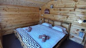 um quarto com uma cama num chalé de madeira em Edelweiss guesthouse, glamping and camping em Suhaia