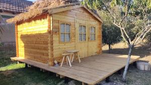 a wooden cabin with a stool on a deck at Edelweiss guesthouse, glamping and camping in Suhaia