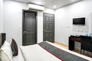 a bedroom with a bed and a desk and a television at Super Townhouse 1263 Shalimar Residency Near Shalimar Bagh Metro Station in New Delhi