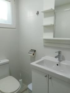 Baño blanco con lavabo y aseo en Finca Azahar Chipiona en Chipiona