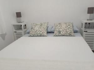 a bedroom with a white bed with two night stands at Finca Azahar Chipiona in Chipiona +10 photos