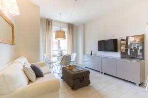 Appartamento Garbino Deluxe - MyHo Casa في مارينا بالمينس: غرفة معيشة مع أريكة وتلفزيون بشاشة مسطحة