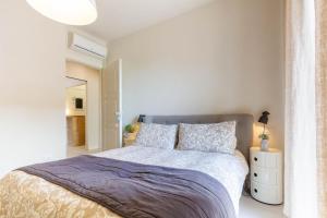 1 dormitorio con cama y pared blanca en Appartamento Garbino Deluxe - MyHo Casa, en Marina Palmense