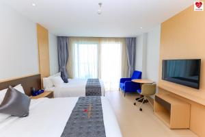um quarto de hotel com duas camas e uma televisão de ecrã plano em Victor Group Condotel Cam Ranh em Cam Lâm