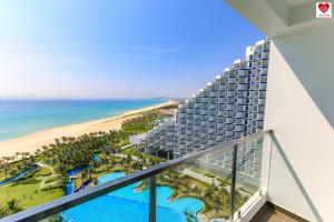 uma vista para a praia a partir da varanda de um resort em Victor Group Condotel Cam Ranh em Cam Lâm