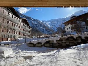 a street covered in snow with buildings and mountains at Berghof in Saas-Fee