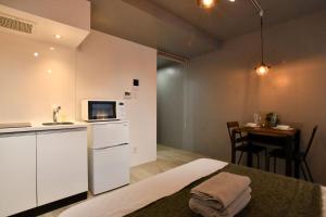 a room with a kitchen and a table with a microwave at FL Residence Shinjyuku I in Tokyo +35 photos
