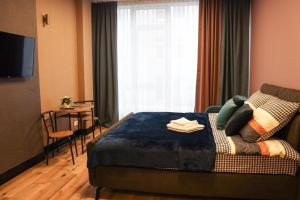 a bedroom with a bed and a table and a window at Hotel Apart in Warsaw
