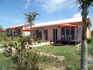 una casa con sombrillas en un patio con un patio en Beach Village Nosoko, en Ishigaki Island