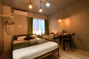 a bedroom with a bed and a table in it at FL Residence Shinjyuku I in Tokyo