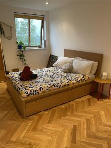 a bed in a bedroom with a wooden floor at Idyllic flat over River Lea in London