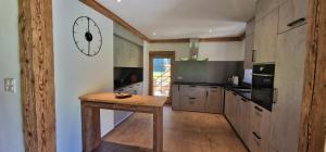 a kitchen with a wooden table and a clock on the wall at Ferme à Marius in Champéry