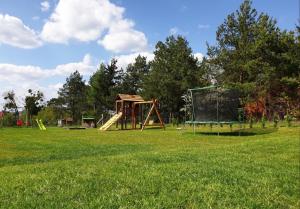 einen Park mit Spielplatz mit Rutsche und Spiel in der Unterkunft Domek z widokiem na jezioro - Domek Jerzy in Kruklanki