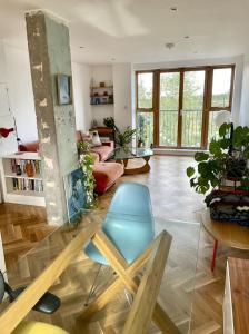 a living room with a glass table and a blue chair at Idyllic flat over River Lea in London