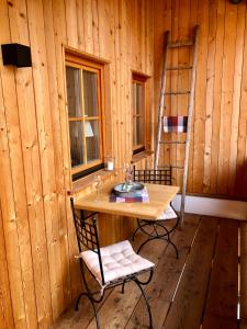 a room with a table and two chairs and a ladder at Chalet Hochgern in Staudach-Egerndach