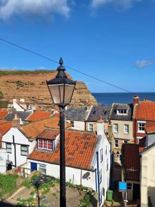 a view of a town with a street light and roofs at The Cottage, High Street Staithes in Staithes