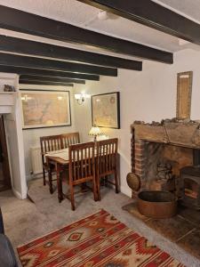 a dining room with a table and a fireplace at The Cottage, High Street Staithes in Staithes