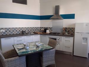 uma cozinha com uma mesa com cadeiras e um frigorífico em Cosy Home Papeete em Papeete