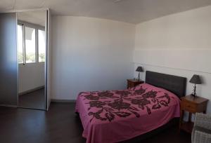 um quarto com uma cama rosa e um espelho em Cosy Home Papeete em Papeete