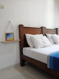 um quarto com uma cama e uma fotografia na parede em La Blue Villa em Dickwella