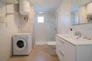 a white bathroom with a washing machine and a sink at Lanzahost Carmenes Comfort in Costa Teguise