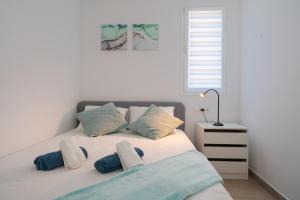 a bedroom with a bed with blue and white pillows at Lanzahost Carmenes Comfort in Costa Teguise