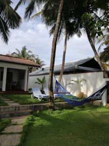 una hamaca frente a una casa con palmeras en La Blue Villa en Dickwella