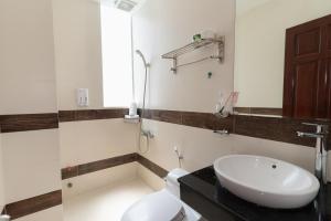 a bathroom with a white toilet and a sink at Sunny Guesthouse2 in Ho Chi Minh City