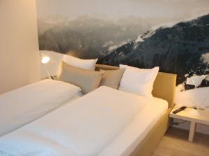 2 Betten in einem Zimmer mit Wandgemälde in der Unterkunft Hotel Restaurant Flaschen in Albinen