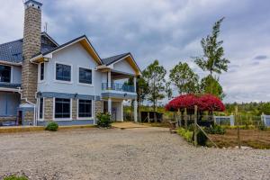 a house with a gravel driveway in front of it at Nanyuki Likizo Castle in Naro Moru