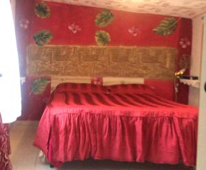 Dormitorio rojo con cama con colcha roja en CASA VACANZE ROSA BLU, en Giffoni Valle Piana