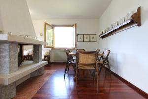 salon ze stołem, krzesłami i kominkiem w obiekcie Vista mozzafiato sulle Dolomiti Friulane w mieście Forni di Sopra
