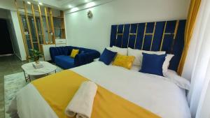 ein Schlafzimmer mit einem großen Bett mit blauen und gelben Kissen in der Unterkunft Hasbi in Nairobi