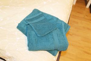 a green towel sitting on top of a bed at Ruhig gelegenes Apartment in Vaihingen an der Enz