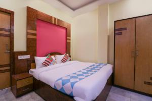 a bedroom with a large bed with a pink headboard at OYO Home Cozy Studio Collage Square Hotel Maya International Near St. Thomas's Church in Kolkata