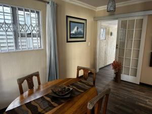 ein Esszimmer mit Tisch und Stühlen und einem Fenster in der Unterkunft Cozy Cottage Accommodation in Johannesburg in Roodepoort