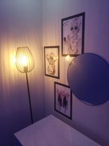 a room with a lamp and pictures on the wall at Charmant F3, 2 chambres + salon à Yoff plage bceao in Dakar