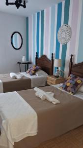 Cette chambre comprend 2 lits et un miroir. dans l'établissement Apartamento Turístico Dalmacia, à Gata