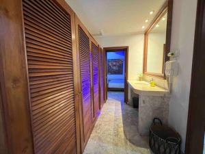 a bathroom with a sink and a wooden wall at Bali Berg Villa, Sanur in Sanur