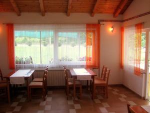 a dining room with two tables and a window at House Sekulic in Grabovac
