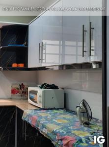 kuchnia z białymi szafkami i kuchenką mikrofalową na ladzie w obiekcie Furnished Luxury Holiday and Vacation Home w mieście Lahaur