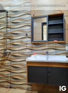 a bathroom with a sink and a mirror on a wall at Furnished Luxury Holiday and Vacation Home in Lahore