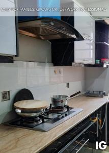 a kitchen with a stove with a pot on it at Furnished Luxury Holiday and Vacation Home in Lahore