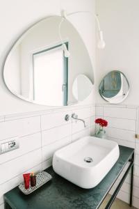 bagno con lavandino bianco e specchio di Casa Saba ospitalità con vista a Rustico