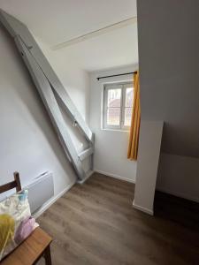 ein leeres Zimmer mit einer Treppe und einem Fenster in der Unterkunft Le Nid de Chantal in Brienne-le-Château