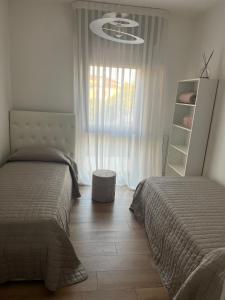 1 Schlafzimmer mit 2 Betten und einem Fenster in der Unterkunft Ca’ Uccelli-Stupendo Appartamento 5 min da Venezia in Marghera