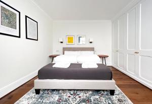 a white bedroom with a bed and a rug at Museum ST Central Soho Apartment in London