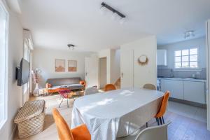 uma cozinha e sala de estar com mesa e cadeiras em Nice house with a yard and common pool - Deauville - Welkeys em Deauville