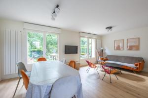 uma sala de estar com uma mesa e cadeiras e um sofá em Nice house with a yard and common pool - Deauville - Welkeys em Deauville