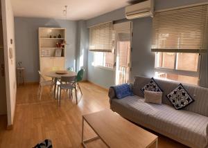 ein Wohnzimmer mit einem Sofa und einem Tisch in der Unterkunft Apartamento Enriqueta in Granada